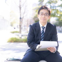 街中で資料を持つ営業部長の爽やかなポートレートの写真