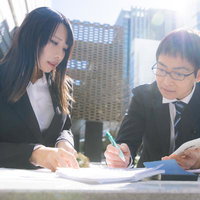 上司と営業資料を見る部下の女性の写真
