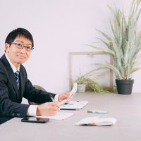 デスクで資料を確認する笑顔の面接官の採用試験の写真