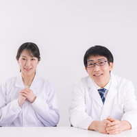 患者の話を親身に聞く医者たち（女性と男性の医局スタッフ）の写真