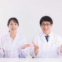 白衣を着た医師二人が両手で提案する様子を示すジェスチャーの写真