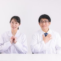 安心してくださいと伝える白衣の男女医師の笑顔でのコミュニケーションの写真