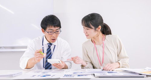 資料を広げながらディスカッションをする男性と女性の職員