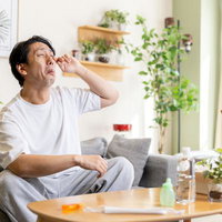 花粉症によって目のかゆみが止まらない男性の写真