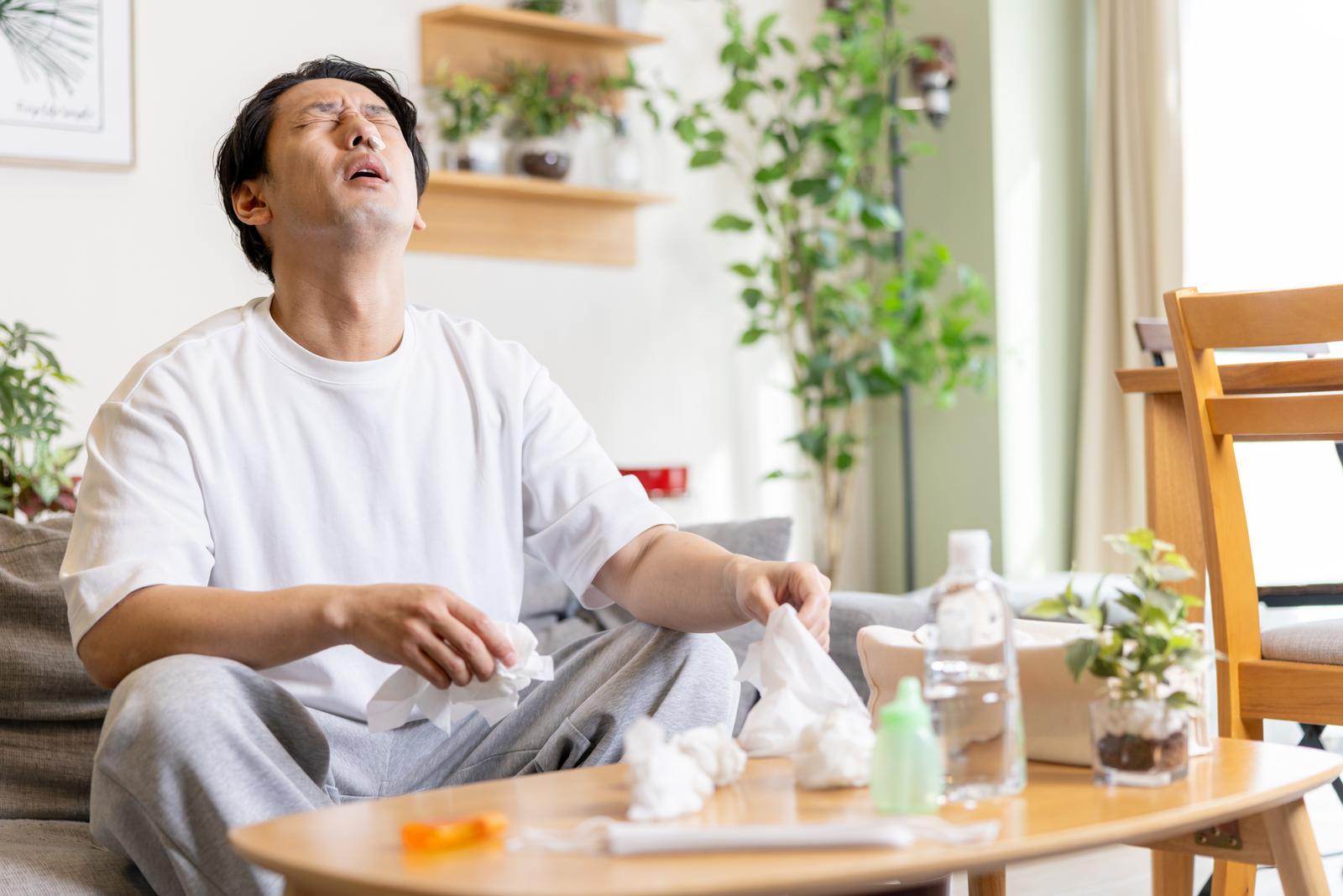 ティッシュを持って上を向く花粉症の男性［モデル：大川竜弥］