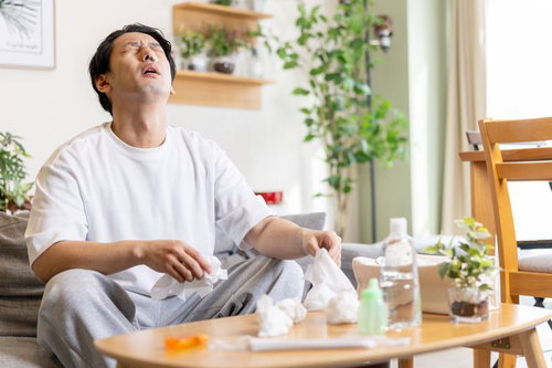 花粉症で鼻をかむ男性がティッシュを持つ様子