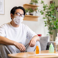 マスクをしてメガネが曇り見えなくなってしまい困る男性の写真