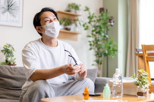 マスクをしながらメガネを拭く男性の花粉症対策