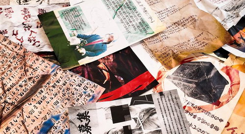 散らばった新聞記事と古い写真の調査資料