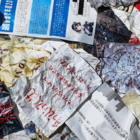 床に散乱したしわくちゃの手書きメモと書類の写真