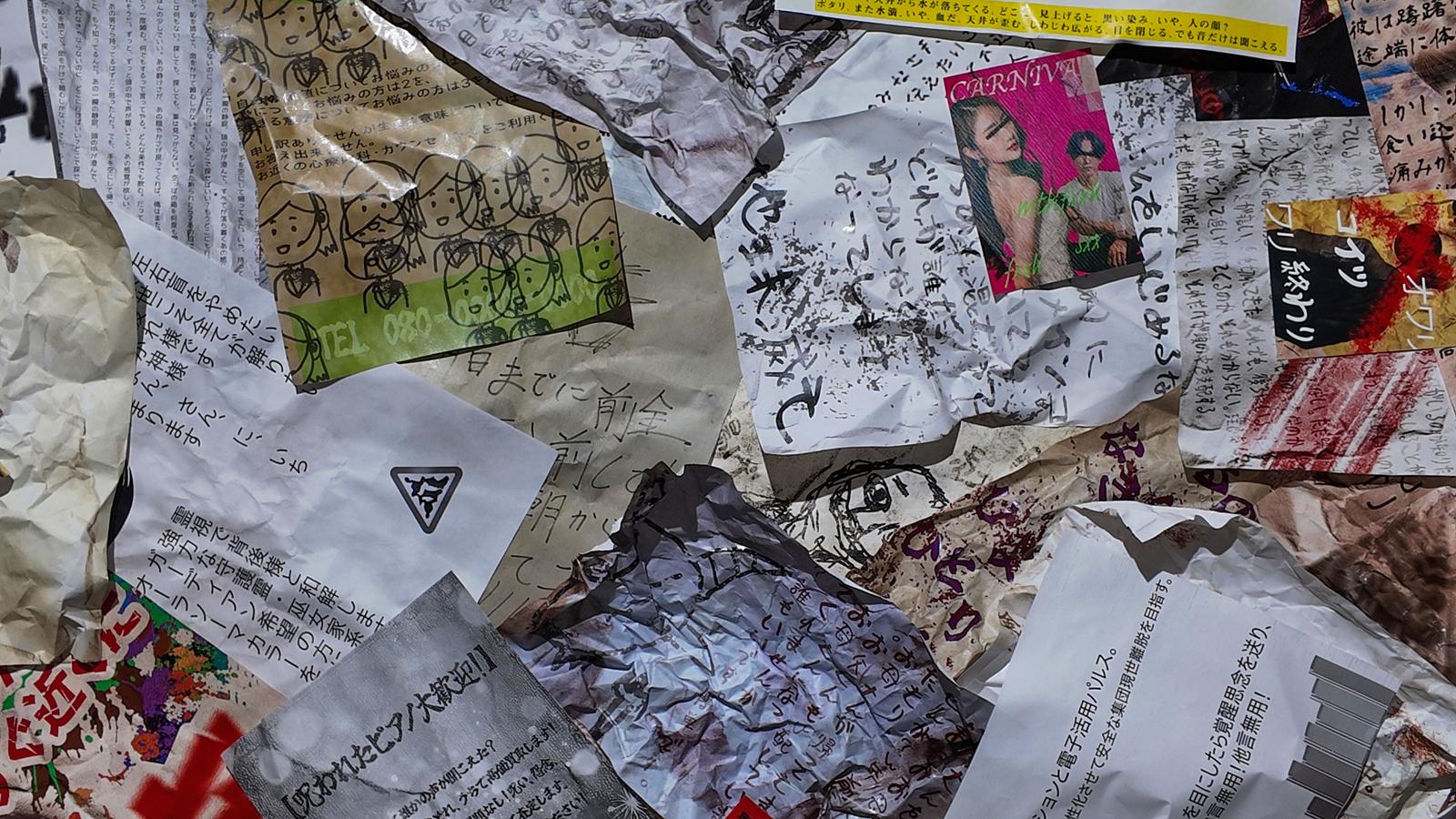 Newspaper and magazine clippings, handwritten notes scattered on the floor
