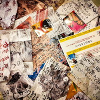 床一面に散乱する手書きの怪文書と紙くずの写真