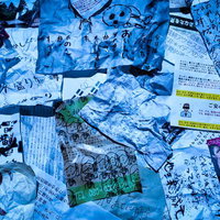青い照明に照らされた散乱する手書きメモと印刷物の写真