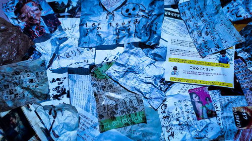 青い照明に照らされた散乱する手書きメモと印刷物