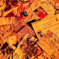 オレンジ照明で照らされた手書き文書の山の写真