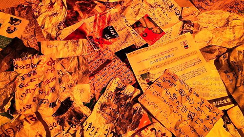 オレンジ照明で照らされた手書き文書の山