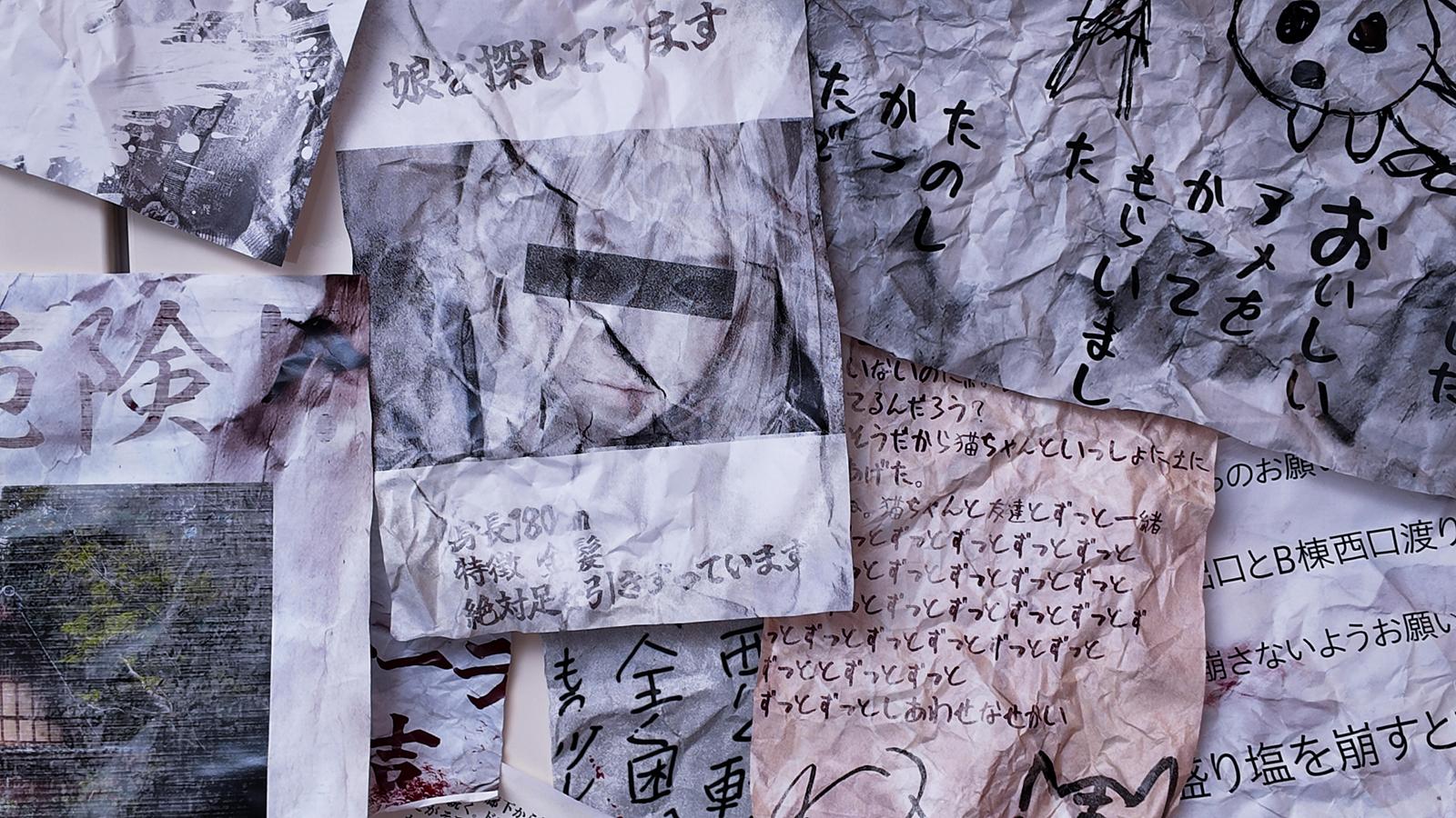 Multiple sheets of crumpled paper with handwritten Japanese text