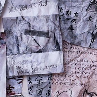 手書き文字で埋め尽くされたしわくちゃな紙の束の写真