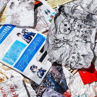 床に散乱した新聞や雑誌の破れた紙片と怪文書の写真