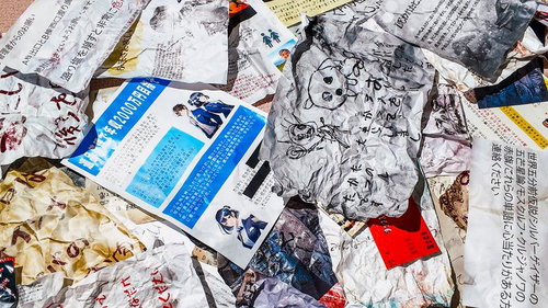 床に散乱した新聞や雑誌の破れた紙片と怪文書