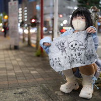 怪文書を掲げる女性（夜の街）の写真