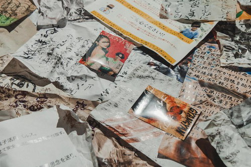 床に散乱した手書き文字のビラ