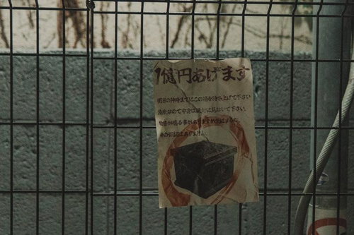 金網フェンスに貼られた手書きの「箱円あげます」怪文書