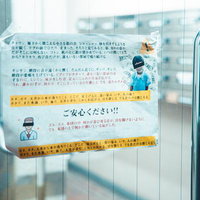 ガラス扉に貼られた感染防止を装う奇妙な張り紙の写真