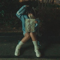 夜の路上で怪文書を読む青い服の女性の写真