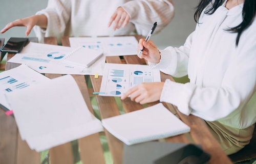 デスクの上でグラフ資料を確認する会議の様子