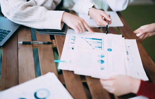 資料のグラフを確認しながら打ち合わせをする様子