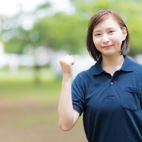 ガッツポーズで応援する介護士の女性スタッフのポートレートの写真