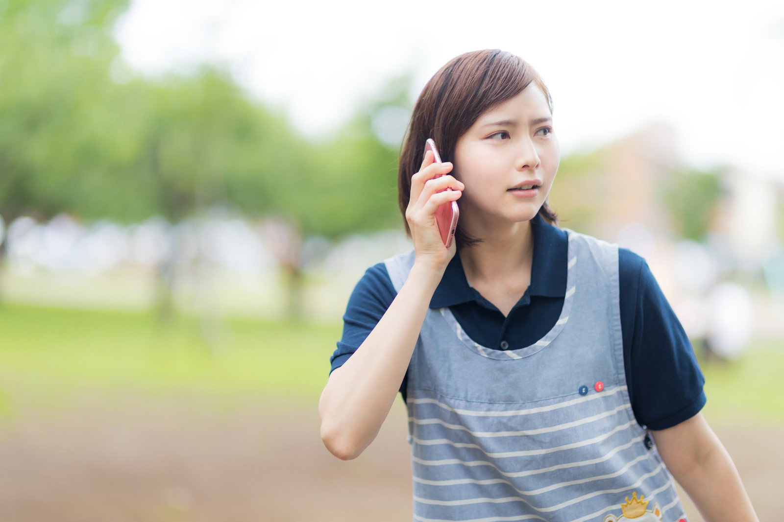 電話をかけながら心配そうな表情で探し回る介護士の女性［モデル：yumiko］
