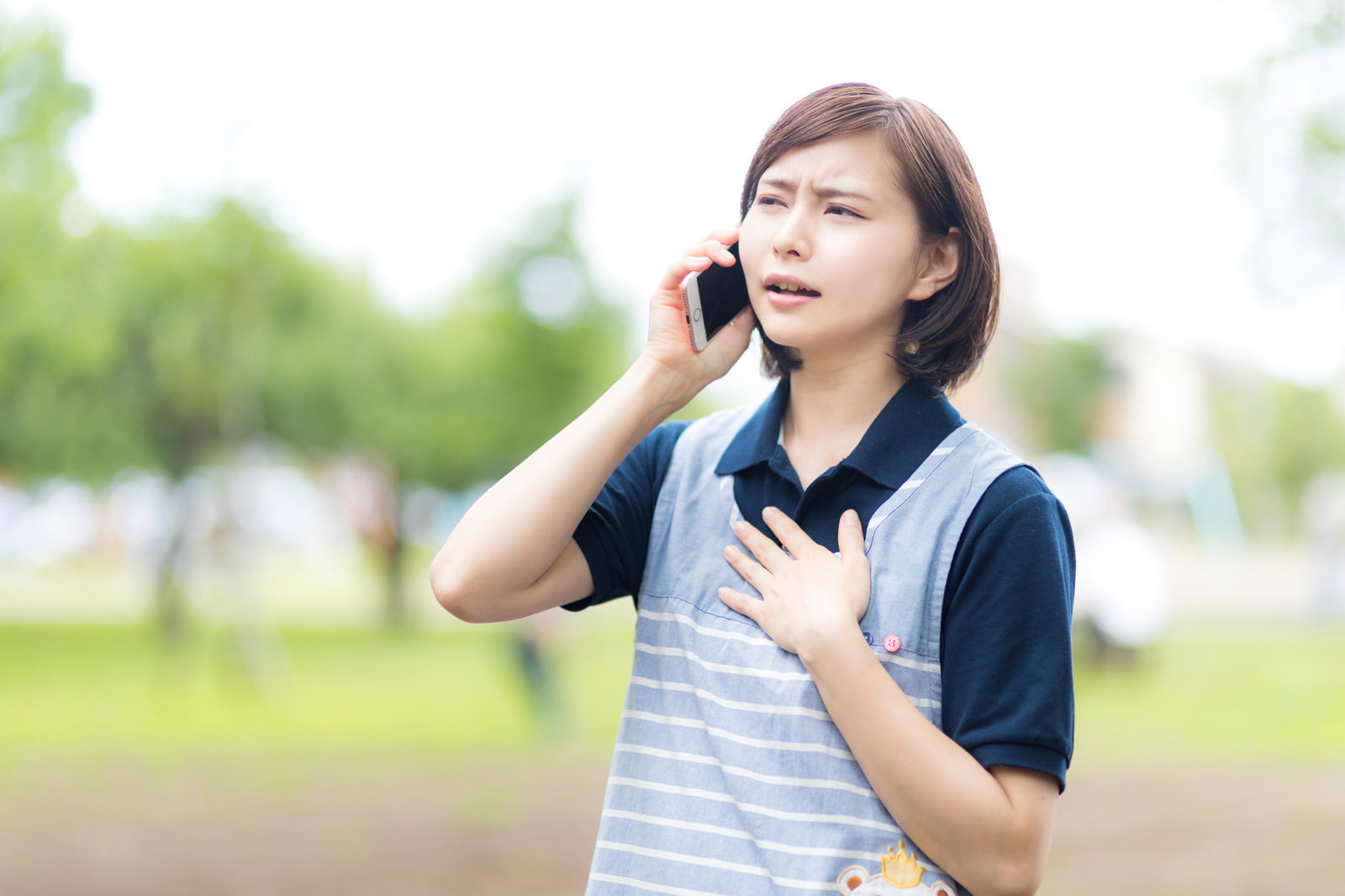 屋外で笑顔で電話をかけている介護士の女性［モデル：yumiko］