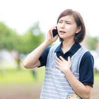 心配事が解消してホッとする介護士の女性が電話で連絡の写真