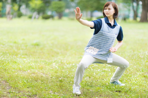 業務前の準備運動をするヘルパー・公園での体操