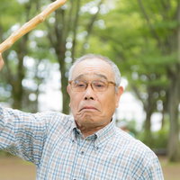 イタズラしたのは誰じゃーと杖を振りかざして怒るおじいさんの写真