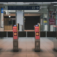 駅構内の赤い自動改札前の通路の写真