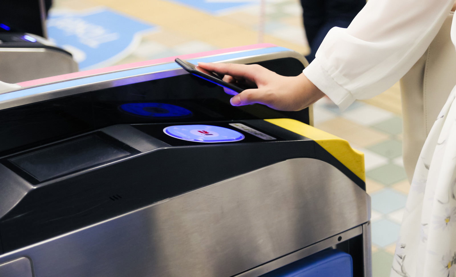 スマートフォンを改札機にかざしてタッチする手元