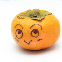 おや！柿が落ちています。顔を描いた秋の味覚の写真