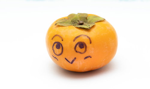 おや！柿が落ちています。顔を描いた秋の味覚