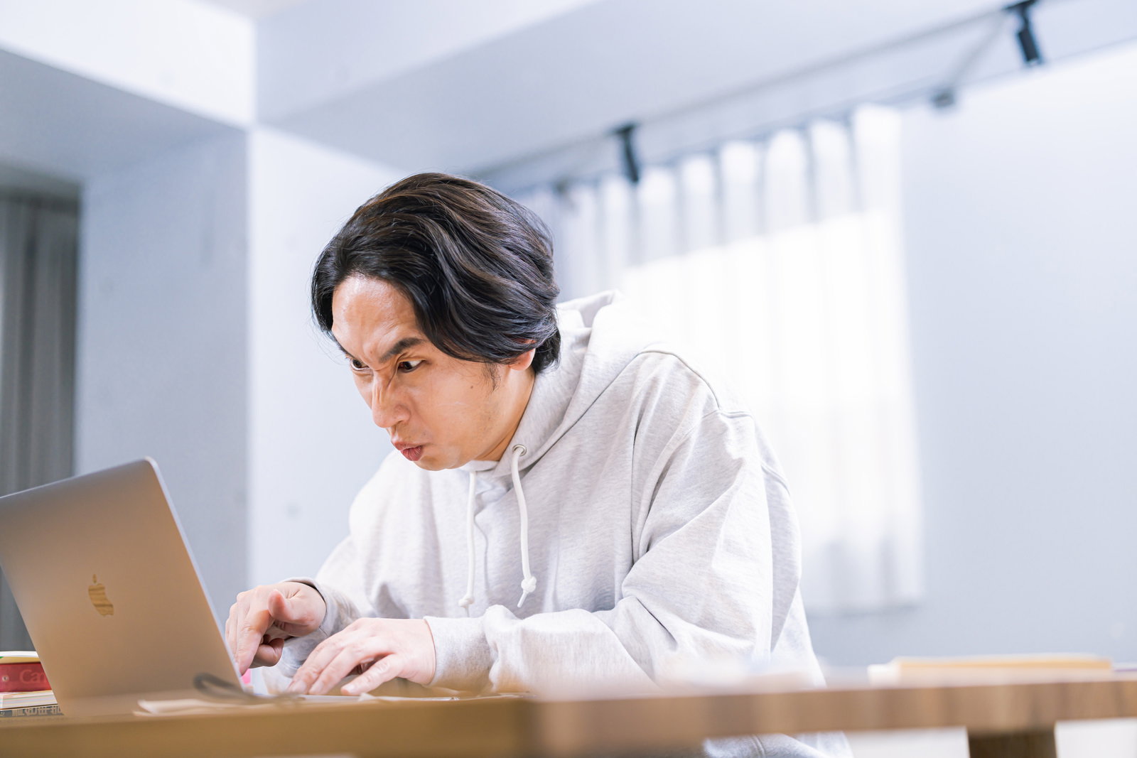 ノートパソコンでデータ入力をする男性個人事業主［モデル：大川竜弥］