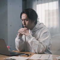 確定申告の画面を見てひどく落ち込むフリーランス男性の写真