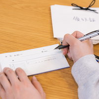 領収書にペンで記入する手元の写真