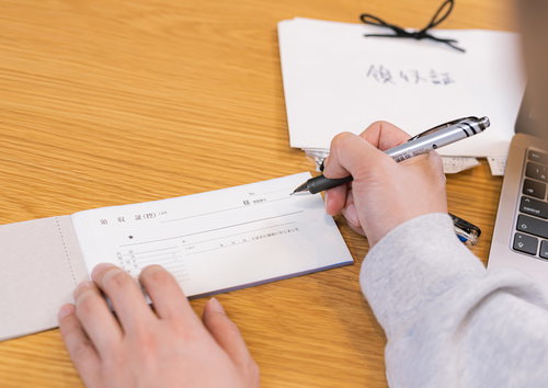 領収書にペンで記入する手元