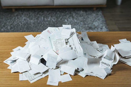 山盛りになった紙の領収書と経費管理・記帳業務