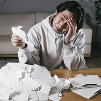 領収書をかき集めて頭を抱える個人事業主の確定申告の写真