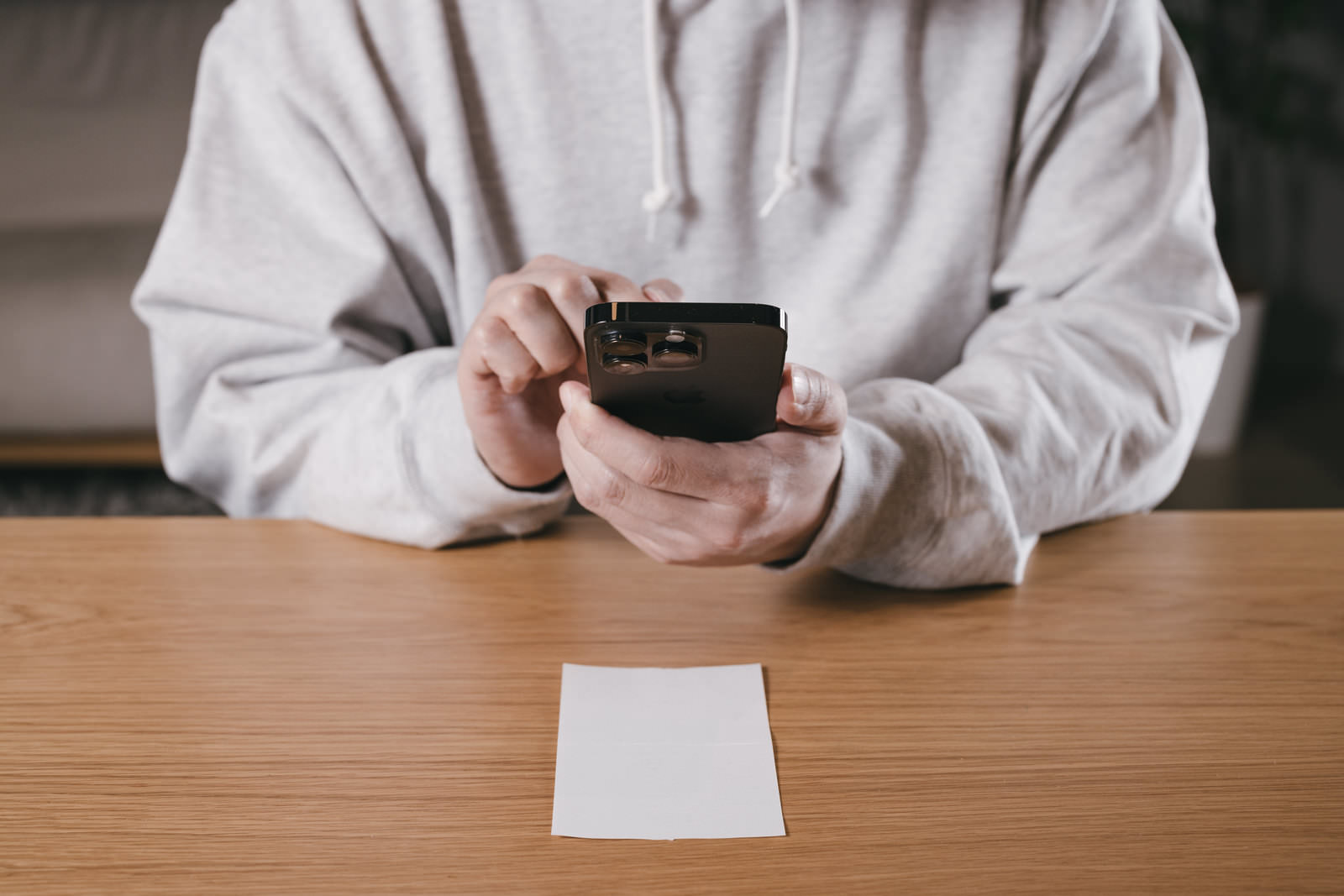 モバイルアプリで領収書をスマートフォンで撮影しPDF化する男性