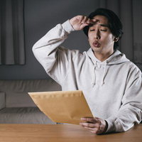 無事に締め切りに間に合わせ、郵送するだけの男性の写真