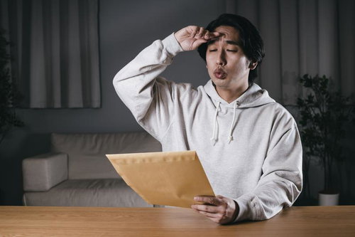 無事に締め切りに間に合わせ、郵送するだけの男性